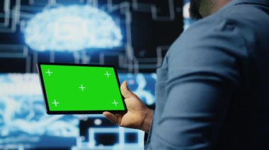 Afrika kökenli Amerikalı mühendis, veri işleme otomasyonu ve yenilikleri için öngörücü analitikleri ve nöral ağları inceleyen, izole edilmiş görüntülü bir tablet gösteriyor. Sibernetik. Kamera B.