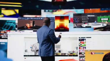 Çevresindeki sosyal bağlantının görsel unsurları, teknoloji iletişimi ve akıllı telefondaki modern dijital platformlarla çevrimiçi içerik ve mobil uygulamalarda gezinen gülümseyen kullanıcı. Kamera A.