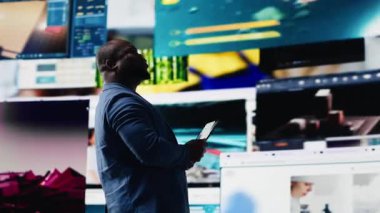 Siyah sosyal medya yöneticisi ekranlarda sosyal ağ eğilimleriyle meşgul, kullanıcı arayüzü ve dijital web platformları sergiliyor. Teknolojinin gücü, nüfuz ve internet bağlantısı. Kamera B.