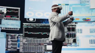 Fon elde etmek için sanal gerçeklik kulaklığıyla çalışan iş lideri, kalkınma planı için ön gösterge panellerindeki performans raporlarını gözden geçiriyor. Maddi durumu analiz etmek için 3D simülasyon. Kamera A.