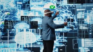 Siyah işadamı, dijital veri işleme ortamında veri bilimi, otomasyon ve yapay zeka etiğini keşfetmek için ileri teknoloji VR kulaklık araçları kullanıyor. Makine öğrenme üzerinde çalışıyor. Kamera A.