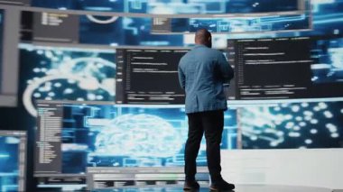 Yenilikçi merkez için Afrika kökenli Amerikan yetenekli mühendis programlama büyük verileri ve gösterge panelindeki ikili kodları gözden geçiriyor. IT geliştiricisi programlama dili algoritması üzerinde çalışıyor. Kamera A.