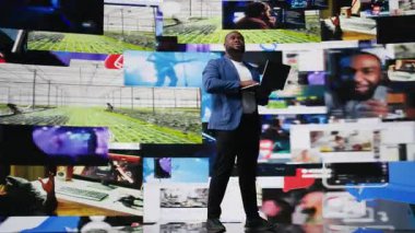 Afrika kökenli Amerikalı uzman, medya göstergeleriyle ilgileniyor, yapay zeka ve teknolojiyle iletişim kurmaya çalışıyor. Teknoloji adamı online platformlar ve internet iletişimi sergiliyor. Kamera A.