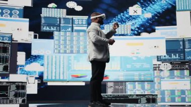 Genç girişimci yönetici, büyük verileri sanal gerçeklik kulaklığıyla değerlendiriyor, kazancı artırmak için iş büyümesi üzerinde çalışıyor. Üretkenlik ve başarı için aylık raporları analiz ediyorum. Kamera A.