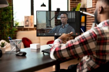 Video konferansındaki profesyonel Afro-Amerikan adam evden uzaktan çalışıyor. Şirket hedefleri ve pazarlama stratejisi konusunda siyahi erkek meslektaşlar arasındaki sanal iş birliği.