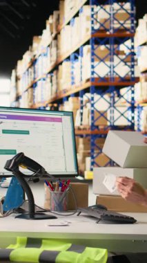 Sevkiyat detaylarını yapışık etiketlerle etiketleyen, sipariş işlemlerini yapan ve paketleri dağıtım için hazırlayan dikey video çalışanı. Çevrimiçi alışveriş tatmin merkezi