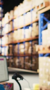 Dikey video Asyalı bir depo işçisi çelik yelek içinde kutulardaki barkod etiketlerini tarıyor, endüstriyel tamamlama merkezinde perakende işlemleri yapıyor. Erkek personel teslimat için AWB kayıt etkinliğine katılıyor