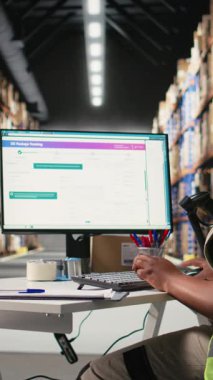 Dikey video depo görevlisi barkodları kayıt altına alıyor, nakliye etiketlerini ve karton kutulardaki yaka kartlarını tarıyor. E-ticaret için tatmin merkezi dağıtım operasyonları. Kamera.