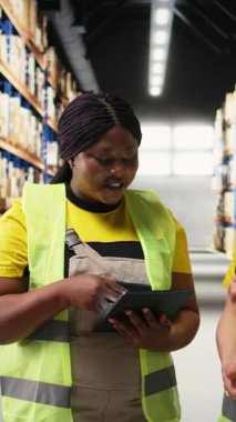 Sipariş işleme ve yerine getirmek için tablet kullanan dikey Video Çeşitli personel, depo alanında ürün paketleme ve kolayca ithalat ürünleri dağıtımı sağlama üzerinde çalışıyor. Kamera A.