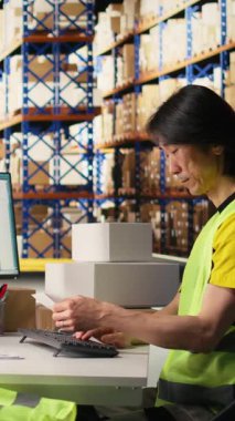 Yelek incelemelerindeki Dikey Videocu endüstriyel depodaki sevkiyat etiketlerinin detaylarını, depolama raflarından gelen paketlerin şifreli ekspres teslimat için takip numaralarını inceler. Kamera.