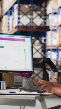 Dikey video depo görevlisi barkodları kayıt altına alıyor, nakliye etiketlerini ve karton kutulardaki yaka kartlarını tarıyor. E-ticaret için tatmin merkezi dağıtım operasyonları. Kamera.