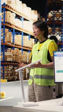 Dikey Videocu Asyalı adam bir videoda büyük iş malzemesi odası aktivitesinin reklamını yapıyor, online alışveriş dağıtım reklamı için bir video bloğu yayınlıyor. Kargoyu tanıtım reklamında sunan adam.