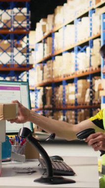 Dikey Videolu Asyalı erkek personel hava yolu fatura bilgilerini kaydetmek için el bilgisayarı kullanır, paket izleme yazılımını barkod okuyucu ve sevkiyat detaylarıyla eş zamanlı olarak günceller. Depo odası