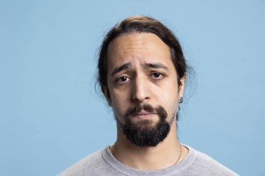 Hayal kırıklığına uğramış, yorgun ve üzgün bir adam. Kamera karşısında sıkıntılı ve cesareti kırılmış. Düşük özsaygı ve duygusal krizle baş ediyor. Depresyondaki mutsuz kişi kaygı ya da kederden muzdarip..