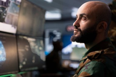 Ordu telekomünikasyon sistemi ajanı radyo ve uydu teknolojisi kullanarak savaş desteği sağlıyor. Orta Doğu askeri iletişim ağlarını yönetiyor, monitörlere bakıyor.