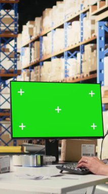 Dikey Video Personeli veri girişi, envanter izleme motifleri ve görsel veya barkod yazıcı arayüzleri için depo odasındaki krom anahtar monitörünü gözden geçirir. Lojistik işçisi kargoyu kargoya yüklüyor.
