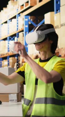 Dikey Video Çalışanı, e-ticaret işlemlerini geliştirmek, envanter ürünlerini incelemek ve paket izleme yazılımındaki paket durumunu izlemek için sanal gerçeklik gözlüğü kullanır. VR kulaklık teknolojisi