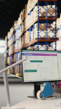 Dikey Videolu Asyalı çalışan hava yolu faturalarını depoya kaydediyor, paket izleme yazılımının sevkiyat detayları için barkod taraması yapıyor. Tamamlama Merkezi envanter takibi