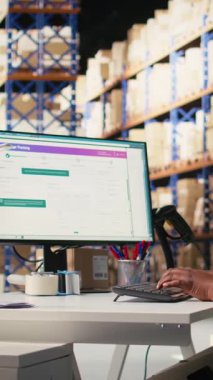 Dikey Video Siyah Kadın Müşteri Destek Memuru müşterilerle sevkiyat detayları hakkında konuşur, yardım hattında yanlış adres karışıklığına yardımcı olur. Kadın siparişi çözer, hava yolu faturalarını onaylar.