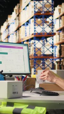 Dikey Video Asyalı personel, teslimattan önce barkodları etiketlemeyi ve taramayı başarıyor, perakende dağıtım için bir depoda yelek giyiyor. Siparişin yerine getirilmesi ve envanter takibi sağlanıyor