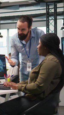 Dikey videolu neşeli iş arkadaşları iş molasında eğleniyor, bağlanıyor, pozitif ofis kültürü kavramını uyguluyor. Kodu optimize etmek için yapay zekayı kullanırken iş arkadaşları şakacı tartışmalar yapıyorlar