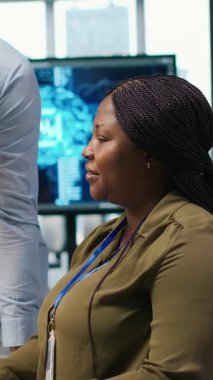 Yapay zeka kullanarak kodları optimize eden kadın programcıyı alkışlayan dikey video memnun ofis yöneticisi. Memnuniyet duyulan takım lideri ofisteki bilişim uzmanı tarafından yapılan çalışmalara olumlu yanıt veriyor.