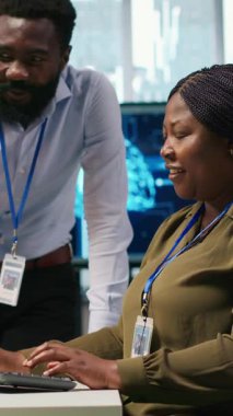 Ofisteki dikey videolu neşeli programcılar sohbetin tadını çıkarırken Al ile tekrarlanan görevleri otomatikleştiriyorlar. Mutlu iş arkadaşları sohbet ediyor, suni zekayı kullanarak özellikleri hızlandırıyor.