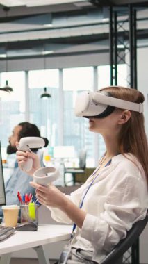 Küçük Dev 'in sanal gerçekliği kullanarak üretken yapay zeka öğrenme algoritmalarını test ettiği dikey video. VR gözlük takan genç bir kadın yapay zeka ile verimliliği ölçeklendiriyor.