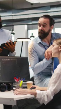 Dikey video Startup yeni katılımcısı ofiste arkadaş ediniyor, makine öğrenme teknolojisini kullanmayı öğreniyor. İş yerindeki neşeli genç kız iş arkadaşlarıyla sohbet ederken yapay zeka öngörüsü modelleri, kamera A kullanıyor.