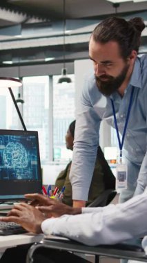 Dikey video başlatma mühendisi ve parapleji beyin fırtınası yapan, makine öğrenme teknolojisiyle çalışan iş arkadaşı. Tekerlekli sandalyedeki adam ve ofisteki iş arkadaşı verileri yapay zeka öngörücü modellerine dönüştürüyor.