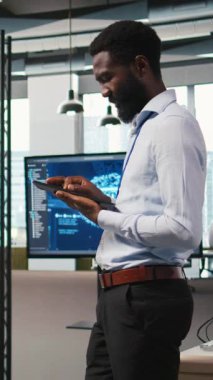 Ofisteki dikey video teknisyeni yapay zeka senaryoları kullanarak tekrarlanan görevleri otomatikleştiriyor. Uzun metrajlı uygulamayı hızlandırmak için yapay zeka kullanan iş yerindeki neşeli adam, kamera A