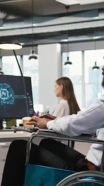 Ofiste belden aşağısı felçli dikey bilgisayar bilimcisi yapay zeka senaryolarıyla tekrarlanan görevleri otomatikleştiriyor. Uzun metrajlı uygulamayı hızlandırmak için yapay zeka kullanan tekerlekli sandalyedeki bilişim uzmanı.