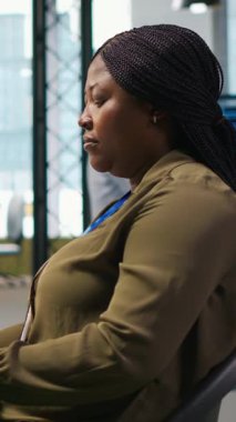 Başlangıç ofisindeki dikey bilgisayar bilimcisi yapay zeka sistem ölçümlerini gözden geçiriyor, performans gösterge panellerini izliyor. Afrika kökenli Amerikalı bir kadın, bilgisayar ve kamera A 'daki araçları kullanarak sinirsel ağları ayarlıyor.