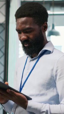 Ofis arkadaşlarının yanında dikey video teknisyeni yazılım uygulamaları geliştiriyor, yapay zeka otomasyonunu entegre ediyor. İş yerindeki geliştiricilerin yanındaki Afrikalı Amerikalı adam hata ayıklıyor