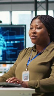 Bilgisayar kullanarak kod yazan dikey video kadın teknisyeni, makine öğrenme API 'leri geliştiriyor. Afrika kökenli Amerikalı kadın yazılım hataları ve hataları için yapay zeka ve kamera kullanıyor.