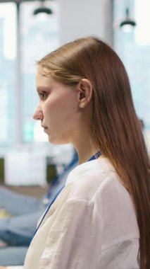 Dikey video Junior dev yazılım uygulamaları geliştiriyor, performans için şifreyi optimize ediyor, müzik dinliyor. Ofiste kulaklık takan genç bayan mühendis. Dar boğazları ve kameraları çözmek için yapay zeka kullanıyor.