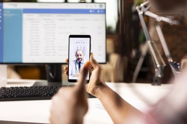 Afrika kökenli Amerikalı bir hastayla görüntülü görüşme sırasında çevrimiçi danışmanlık yapan beyaz erkek hekime odaklanın. Kafkasyalı doktor sanal buluşmada siyahlara uzaktan yardım ediyor..