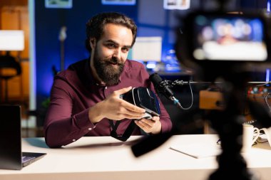 Uzman teknisyen profesyonel kamera kullanarak stüdyodaki VR gözlüklerini inceliyor. Uzman ekipman kullanan, sanal gerçeklik kulaklığı gösteren medya yıldızı teknoloji kanalı vlog 'u
