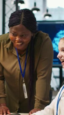 Dikey video yönetmeni stajyerlerin gelişimini cesaretlendirici kelimelerle överek tebrik ediyor. Gülümseyen takım lideri iş yerindeki genç bayan mühendis ve kamera için olumlu geri bildirim sağlıyor