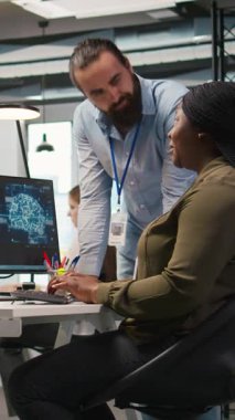 Yapay zeka kullanarak kodları optimize eden kadın programcıyı alkışlayan dikey video memnun ofis yöneticisi. Memnuniyet duyulan takım lideri ofisteki bilişim uzmanı tarafından yapılan çalışmalara olumlu yanıt veriyor.