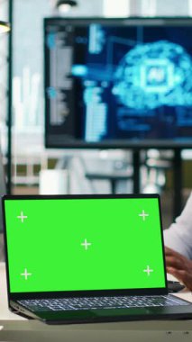 İşletme analizleri için yapay zeka modelleri geliştiren yeşil ekran dizüstü bilgisayar kullanan dikey video Startup ofis programcısı. BT uzmanı Yapay Zeka için simülasyonları çalıştıran bir dizüstü bilgisayar kullanıyor