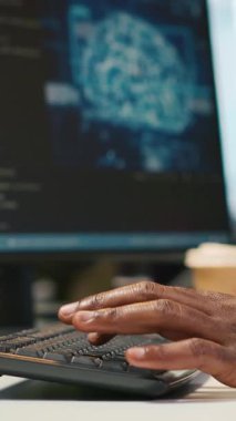 Ofis masasındaki dikey video sistemi yöneticisi yapay zeka otomasyonunu kullanarak yazılım uygulamaları geliştiriyor. Bilgisayar üzerinde çalışan bir bilişim uzmanı, yapay zekayla hata ayıklama uygulamaları, kamera