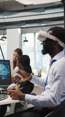 Ofis masasında VR kulaklık takan dikey video programcısı yapay zeka otomasyonunu kullanarak program geliştiriyor. Sanal gerçeklik teknolojisi kullanan girişimci, uygulamaları yapay olarak hata ayıklıyor