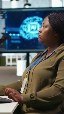 Bilgisayardaki yapay zeka sinir ağı teknolojisini kullanarak performans ve tahminleri optimize eden dikey video yönetmeni. Ofisteki kadın bilgisayar kullanarak yapay zeka eğitimi alıyor.