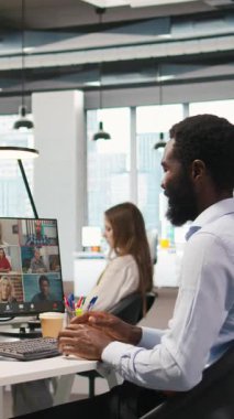 Dikey video teknisyeni ofis ekibi video çağrısı ile iş birliği yapıyor, veri kaybına karşı korumak için yedek çözümler üzerinde beyin fırtınası yapıyor. Çevrimiçi iken yapay zeka kodlaması yapan uzak geliştiriciler