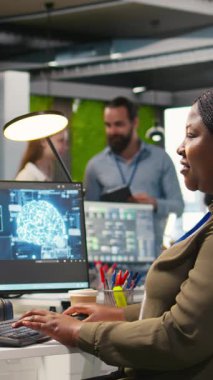 Bilgisayar kullanarak kod yazan dikey video kadın teknisyeni, makine öğrenme API 'leri geliştiriyor. Afrika kökenli Amerikalı kadın yazılım hataları ve hataları için yapay zeka ve kamera kullanıyor.