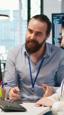 Dikey video arkadaş canlısı ekip lideri genç mühendis kodlu yapay zeka algoritmalarına yazılım sorunlarını çözmede ve sistem istikrarını geliştirmede yardım ediyor. Teknik açılışta gülümseyen stajyere yardımcı yönetici