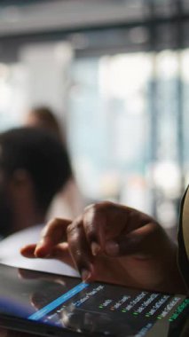 Mühendisin kod yazmak için tablet kullanarak makine öğrenme API 'lerini geliştirdiği dikey video. Yapay zeka ve kamera A 'yı kullanarak bilgi işleme yazılımı hataları ve hataları