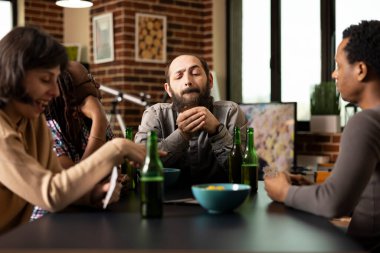 Beyaz adam masadaki arkadaşlarıyla poker oynarken bir sonraki hamlesini planlıyor. Çeşitli gruplar iskambil kağıtları, bira ve abur cuburlar üzerinde sohbet, hafta sonu eğlencesine duvar odasında takılmalar..