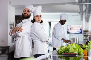 Gurme şeflerden oluşan bir ekip mutfakta profesyonel bir yemek üzerinde birlikte çalışıyorlar, yemek pişirme becerilerini birleştiriyorlar ve restoran menüsü için lezzetli bir gurme yemeği hazırlıyorlar. Güzel yemek..